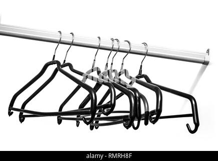 Many black  hangers on a rod, isolated on white wall background Stock Photo