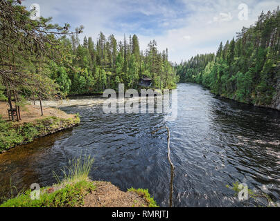 Oulanka river and the fast-moving rapids at the Oulanka National Park in Kuusamo, Finland. Green forest framing the flowing water. Finnish nature on a Stock Photo