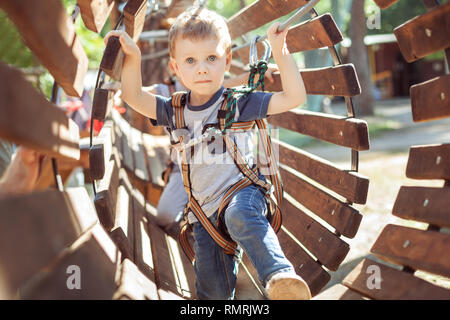 Little boy overcomes an obstacle in an extreme park. Stock Photo