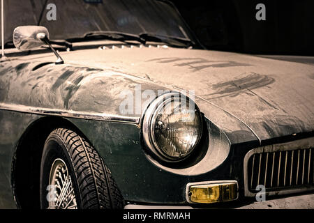 Close up of a headlight of a dusty old green car Stock Photo