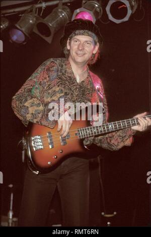 Arc Angels bassist Tommy Shannon is shown having fun on stage during a concert performance. Stock Photo