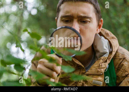 Portrait of young botanist with magnifying glass Stock Photo