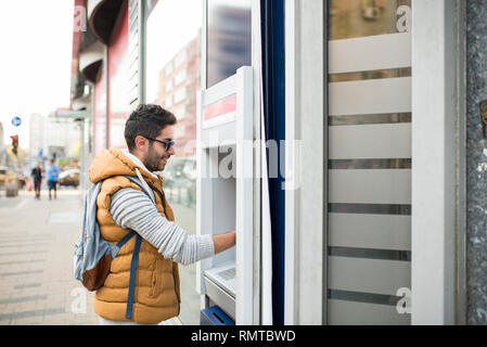 The tourist withdraws money from the ATM for further travel. Finance, credit card, withdrawal of money. Life style. Journey. Vacation. Stock Photo