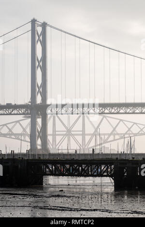 The old Forth Road bridge with the Forth Railway Bridge in the background on a misty day, Queensferry, Scotland Stock Photo