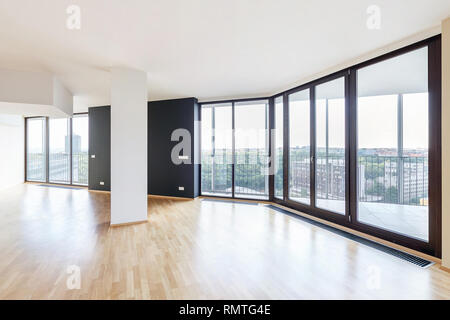 Modern white empty loft apartment interior with parquet floor and panoramic windows, Overlooking the metropolis city Stock Photo