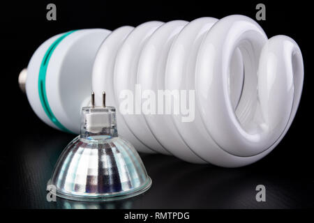 Different light bulbs and fluorescent lights on a wooden table. New types of lighting. Dark background. Stock Photo