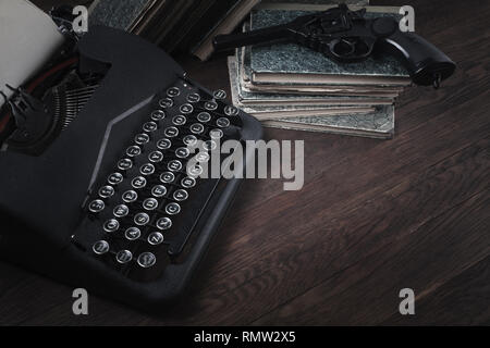 Crime fiction - old retro vintage typewriter and revolver handgun on wooden table