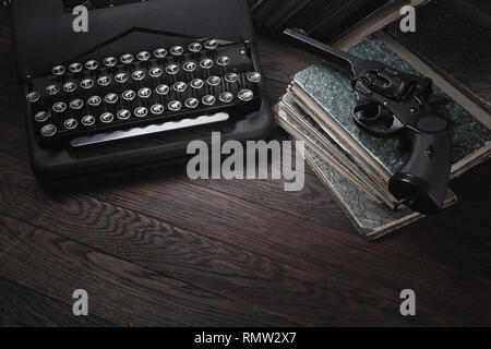 Crime fiction - old retro vintage typewriter and revolver handgun on wooden table
