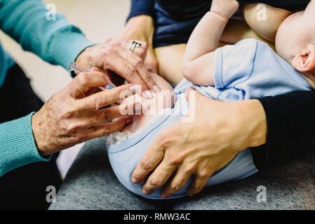 Real baby being vaccinated with a syringe in the thigh by a pediatrician doctor to avoid the spread of diseases. Stock Photo