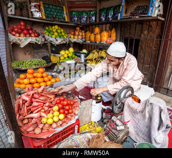 AGRA, UTTAR PRADESH, INDIA - FEBUARY 24, 2015: Muslim man making fresh carrot juice in his shop on the Taj Ganj Street Stock Photo