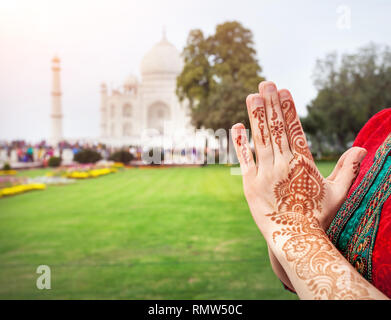 Woman hands with henna painting in Namaste gesture near Taj Mahal in Agra, Uttar Pradesh, India Stock Photo