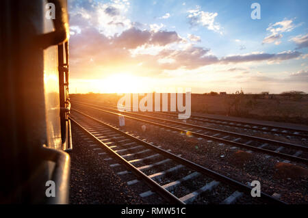 Train passing desert area at sunset sky beckgroung in Rajasthan, India Stock Photo