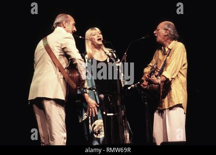 The folk singing trio of Peter, Paul and Mary are shown performing on stage during a 'live' concert appearance.