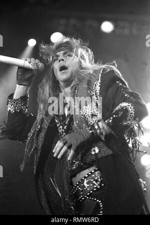 Lead singer Brett Michaels of the glam metal band Poison is shown performing on stage during a 'live' concert appearance. Stock Photo