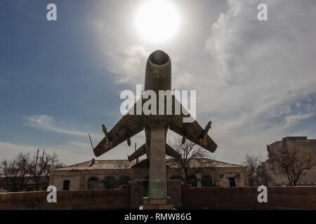 an exhibit of a retro warplane on a background of an abandoned building on a sunny day Stock Photo