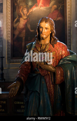 A lit statue of Jesus in a church in Milan, Italy. Stock Photo