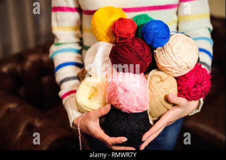 Young pretty woman holding many colorful yarn clews. Stock Photo