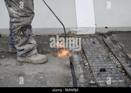 Worker on the bridge in a new highway. Construction worker on bridge. Sticking empty channels on the bridge Stock Photo