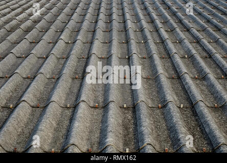 Old gray concrete roof tiles with dirt stains all over the sheet has been used for a long time, one point perspective view. Stock Photo