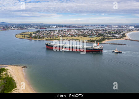 A large coal transport ship entering Newcastle Harbour - Newcastle is one of the largest coal export ports in the world providing thermal and coking c Stock Photo
