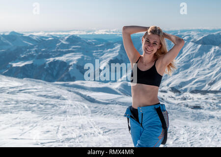 Smiling woman wearing bikini top and winter sportswear in ski resort Gudauri, Georgia Stock Photo