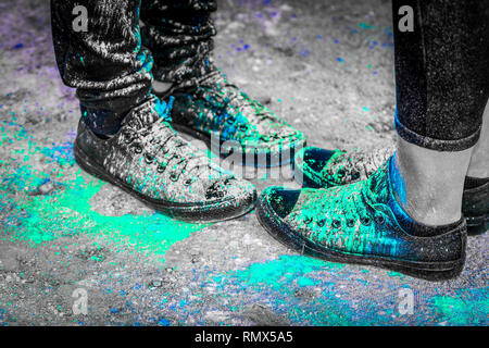 Black running shoes covered in colorful powder paint Stock Photo