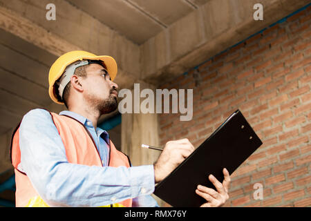 Engineer or inspector checking progressing work in construction site Stock Photo