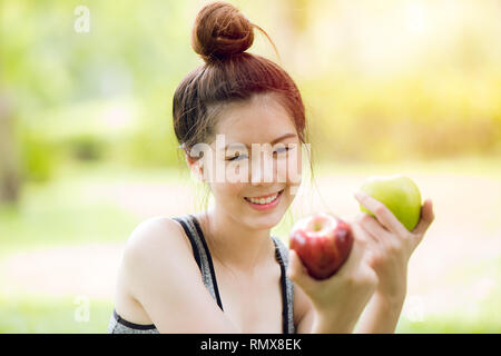 apple in Asian girl hand, green or red apple color fruit choice for healthy people concept. Stock Photo
