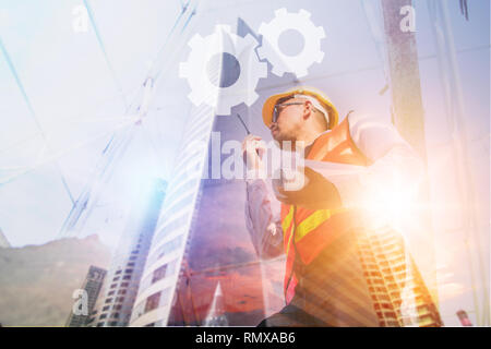 Construction concept, exposure of  engineer talking on radio with tower building background Stock Photo