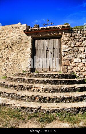 Old cemetery wooden door with wrought iron details on a stone facade in Riopar, Albacete, Spain. Stock Photo