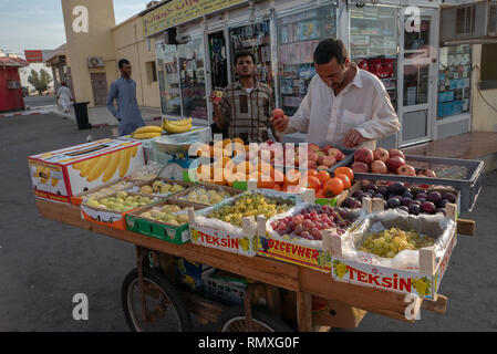 MEDINA, SAUDI ARABIA-CIRCA 2016 : Arabs sell fresh fruits at a highway stop towards Mecca from Medina, Saudi Arabia. Stock Photo