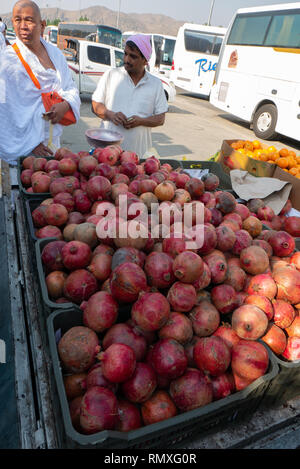MEDINA, SAUDI ARABIA-CIRCA 2016 : An Arab seller sells pomegranate to a Malaysian pilgrims. Stock Photo