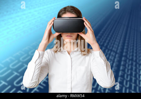 Young woman in white shirt adjusting 3D goggles on her head, holding black device with both hands, experiencing virtual reality. Half-length front por Stock Photo