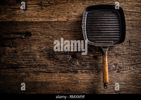 Empty old grill pan on rustic oak table - top of view. Stock Photo