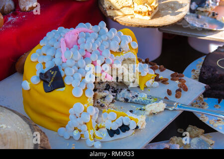 Originally baked tasty buns, loaves and muffins on a tray against the background of the table. The concept of delicious and healthy food. Stock Photo