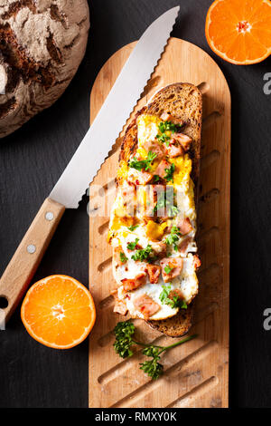 Food concept organic french Sourdough toasted with eggs and ham on wooden cutting board