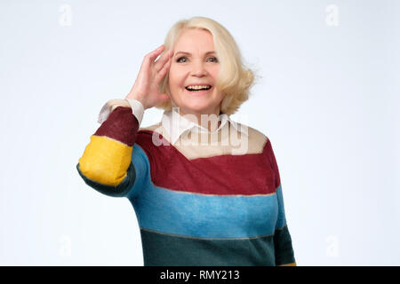 Eureka, finally got answer on question. Senior woman holding fingers on temple Stock Photo