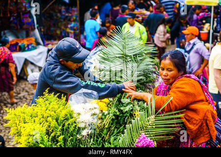 Chichicastenango, Guatemala on 2th May 2016: View on Indigneous woman with colorful clothes selling flowers on market in Chichicatenango Stock Photo