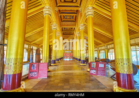 BAGO, MYANMAR - FEBRUARY 15, 2018: The splendid interior of restored wooden Kanbawzathadi Golden palace with lines of tall coumns and carved ceiling, 