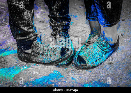 Black running shoes covered in colorful powder paint Stock Photo - Alamy