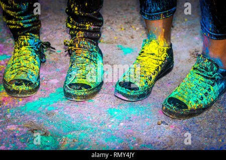 Black running shoes covered in colorful powder paint Stock Photo - Alamy