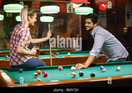 young couple enjoying playing billiard game Stock Photo