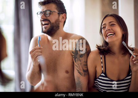 young happy couple brushing their teeth. Stock Photo