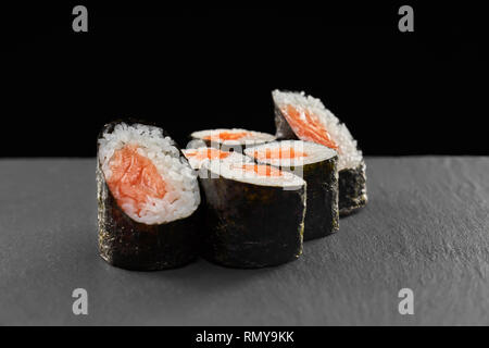 Delicious sake maki sushi rolls with smoked salmon, white rice, wrapped in nori. Concept of japanese food, sushi menu. Stock Photo