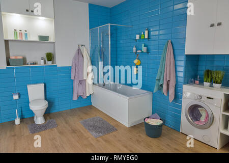 modern bathroom with white toilet bowl and blue tile Stock Photo