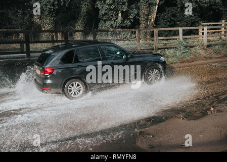 Cars splashing up water as they go through a ford Rufford Stock Photo