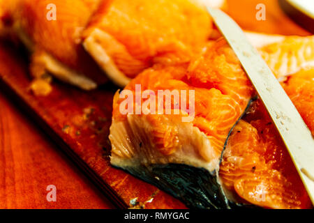 Salmon cuts pieces on a cutting board with a knife isolated Stock Photo