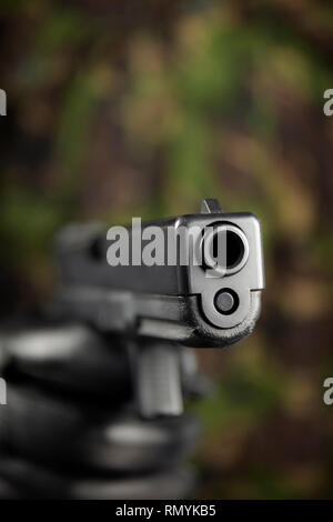 Glock 17 9mm pistol, with camouflage background. Stock Photo