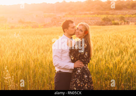 Man and woman embracing and kissing in wheat  field on the dusk,  countryside Malta Stock Photo