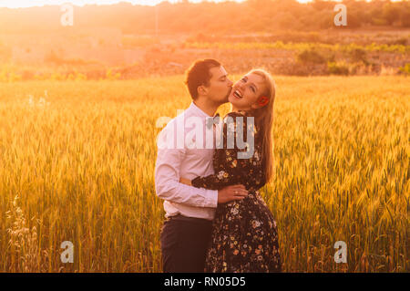 Man and woman embracing and kissing in wheat  field on the dusk,  countryside Malta Stock Photo